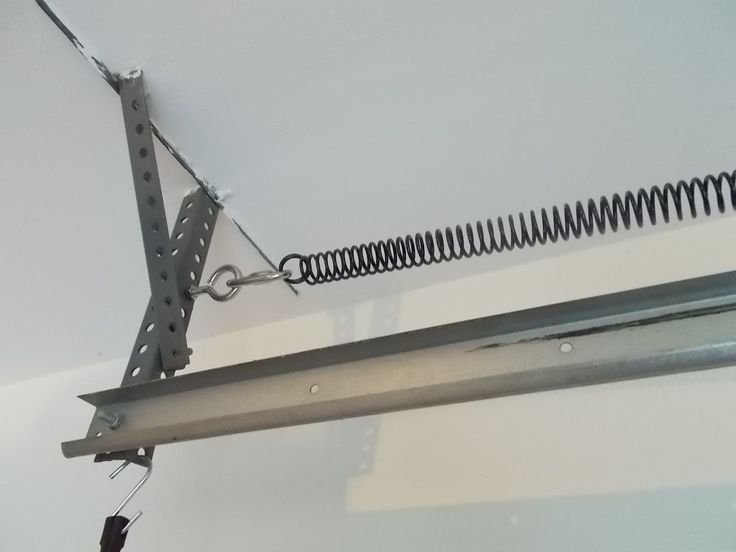 Technician installing a torsion spring on a residential garage door